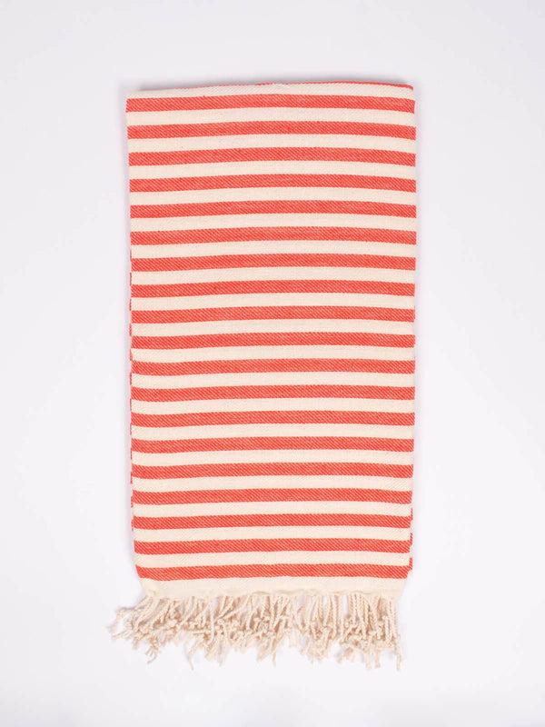 Folded striped orange and cream towel, with cream colored tassels